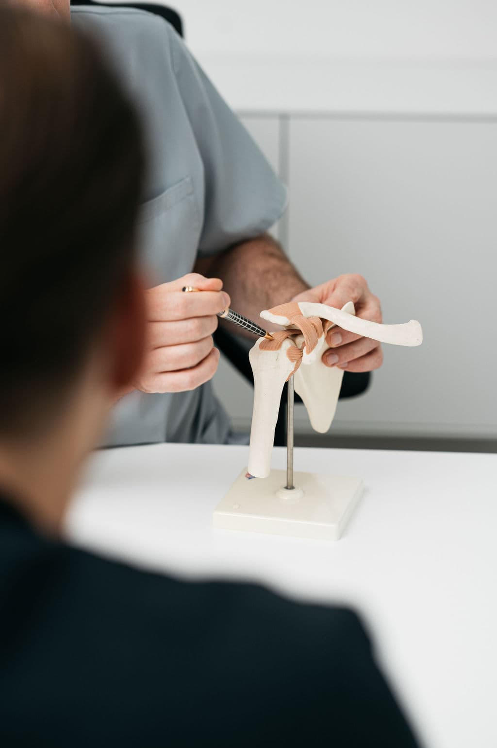 De osteopaat geeft uitleg over de klacht aan de patiënt